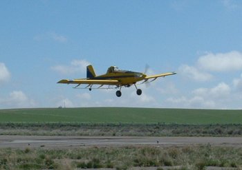 Turbine ag aircraft on approach over a green field